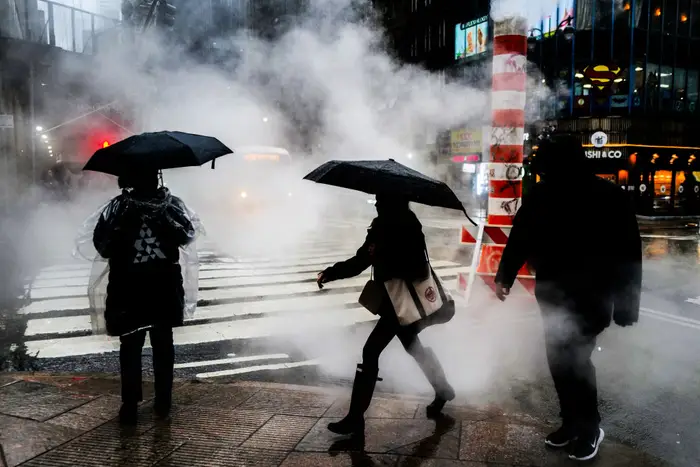 Pedestrians walk in the rain in Manhattan on March 23, 2024.